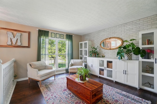 5694 Danmar Dr, Canal Winchester, OH 43110 - sitting room with brick wall, a textured ceiling, dark wood-style floors, and baseboards