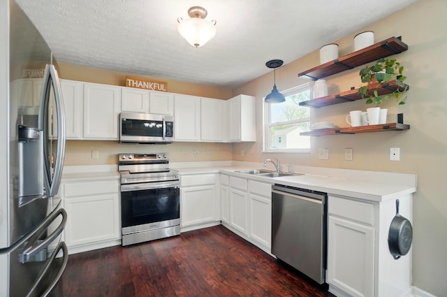 5694 Danmar Dr, Canal Winchester, OH 43110 - kitchen with appliances with stainless steel finishes, a sink, dark wood-style floors, white cabinetry, and light countertops