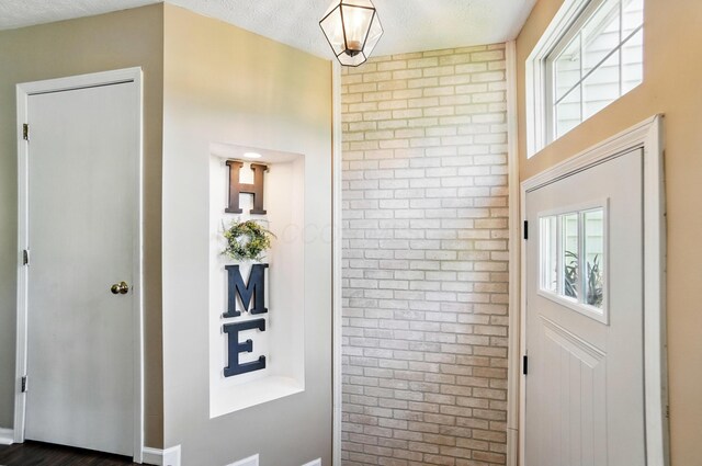 5694 Danmar Dr, Canal Winchester, OH 43110 - entryway with brick wall, plenty of natural light, and a textured ceiling