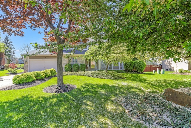 obstructed view of property featuring a front lawn, driveway, an attached garage, and fence