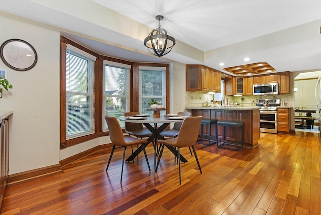 dining area with recessed lighting, an inviting chandelier, hardwood / wood-style floors, and baseboards