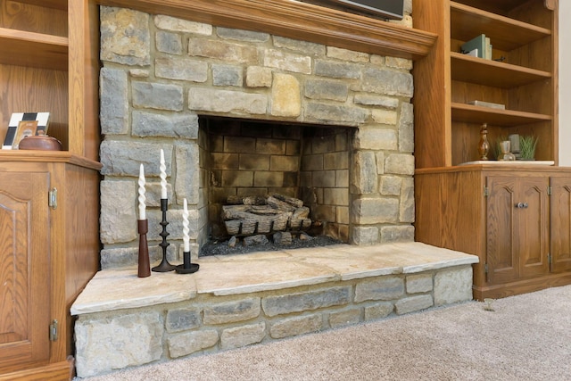 interior details with a stone fireplace and carpet floors