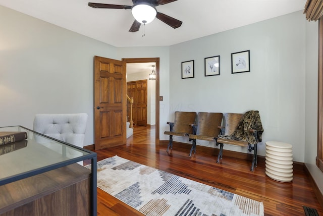 interior space with wood finished floors, ceiling fan, and visible vents