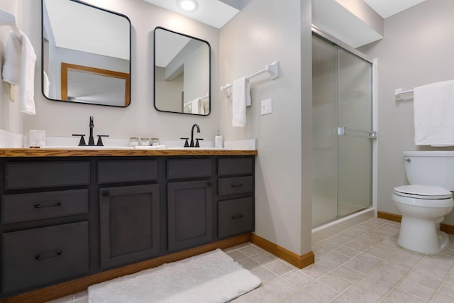 bathroom featuring a sink, toilet, a stall shower, double vanity, and tile patterned flooring