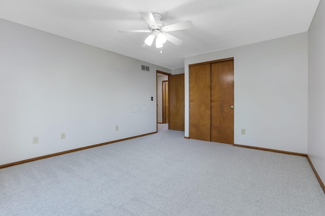 unfurnished bedroom with baseboards, visible vents, light carpet, and a closet