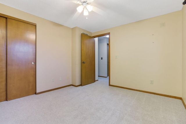 unfurnished bedroom featuring a closet, baseboards, and light carpet