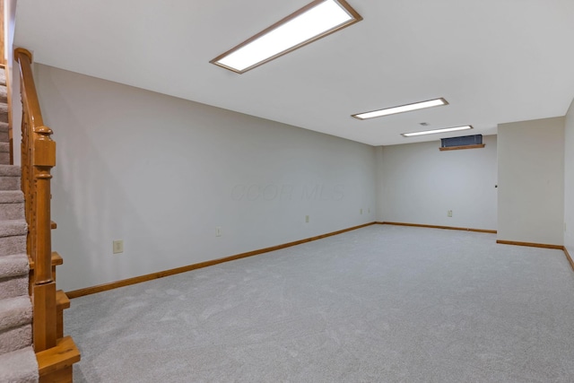 finished below grade area with baseboards, stairway, and carpet