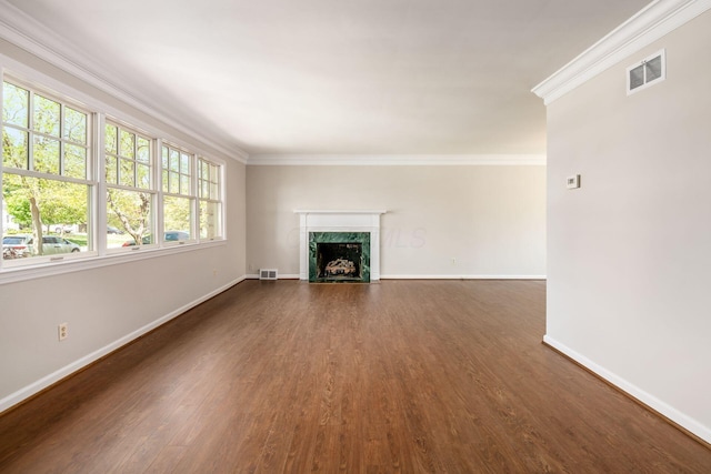 unfurnished living room with visible vents, baseboards, crown molding, and dark wood-style floors