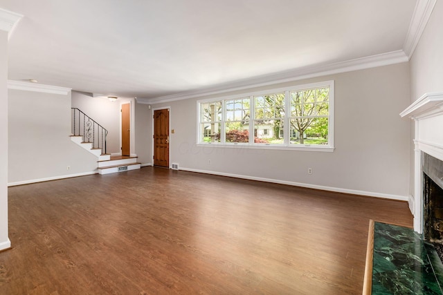 unfurnished living room with crown molding, a high end fireplace, dark wood-style flooring, and stairway