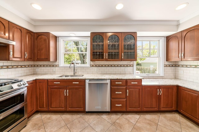 kitchen with crown molding, light tile patterned flooring, tasteful backsplash, a sink, and appliances with stainless steel finishes