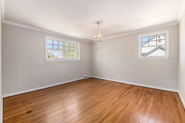empty room with light wood-style floors, visible vents, crown molding, baseboards, and an inviting chandelier