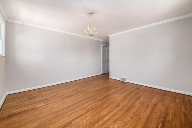 unfurnished room with visible vents, crown molding, baseboards, light wood finished floors, and a notable chandelier