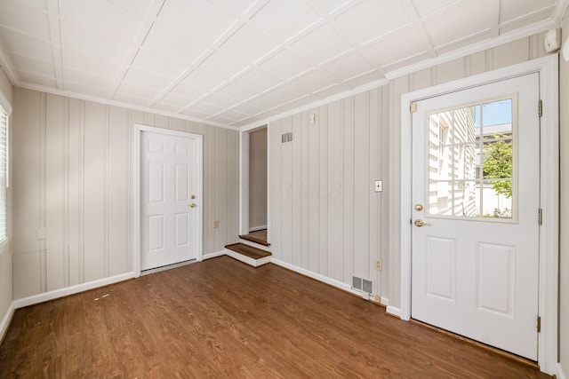 foyer entrance featuring baseboards, visible vents, ornamental molding, and dark wood-type flooring