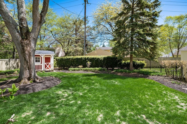 view of yard with an outbuilding, a shed, and a fenced backyard