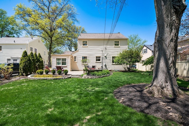 back of property with a yard, fence, and a patio area