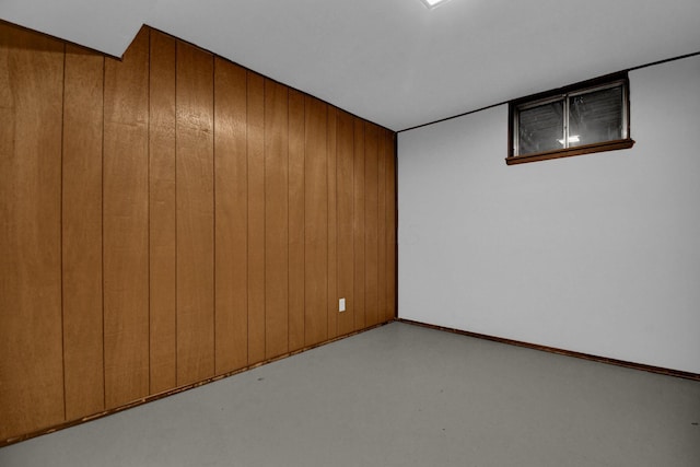 empty room with concrete floors and wooden walls