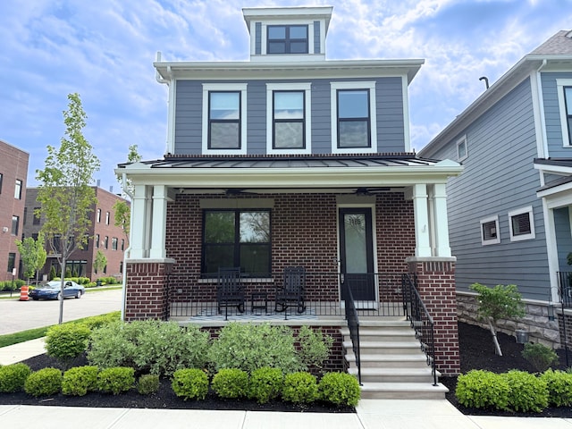 american foursquare style home featuring covered porch and brick siding