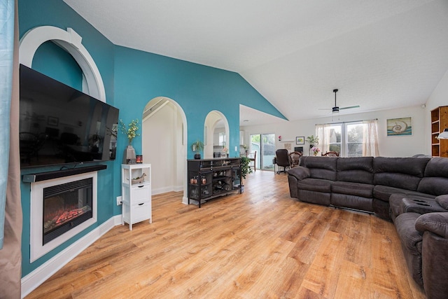 380 Oak Village Dr, Columbus, OH 43207 - living area featuring wood finished floors, a glass covered fireplace, vaulted ceiling, a ceiling fan, and baseboards