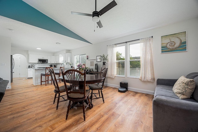 380 Oak Village Dr, Columbus, OH 43207 - dining room featuring a ceiling fan, light wood-type flooring, vaulted ceiling, a textured ceiling, and baseboards