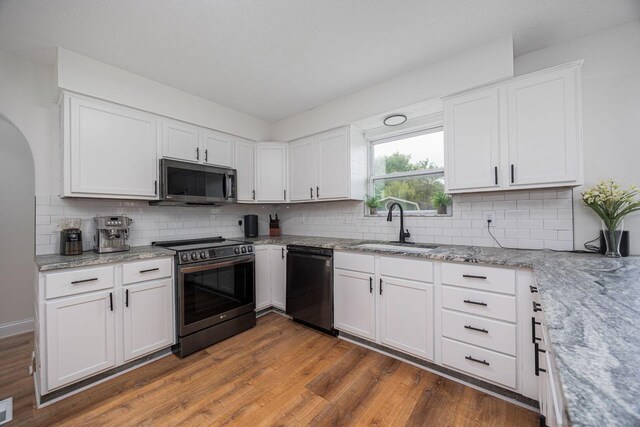 380 Oak Village Dr, Columbus, OH 43207 - kitchen featuring appliances with stainless steel finishes, a sink, light stone countertops, and wood finished floors