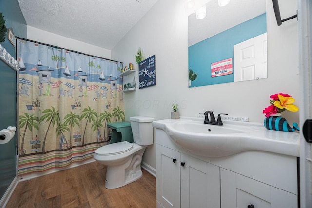 380 Oak Village Dr, Columbus, OH 43207 - full bath featuring wood finished floors, vanity, toilet, a textured ceiling, and curtained shower