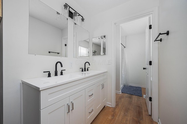 380 Oak Village Dr, Columbus, OH 43207 - full bath with double vanity, wood finished floors, curtained shower, and baseboards