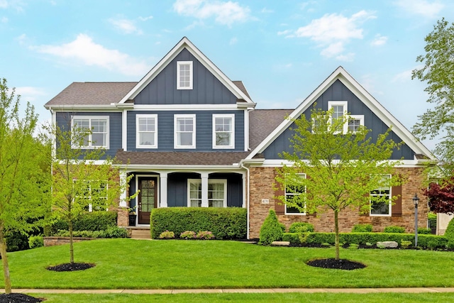 craftsman-style home featuring a shingled roof, board and batten siding, and a front yard