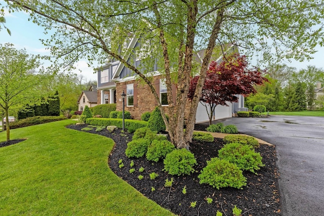 view of side of property featuring a lawn and aphalt driveway