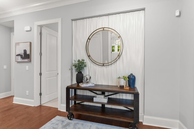 corridor featuring baseboards, ornamental molding, and wood finished floors