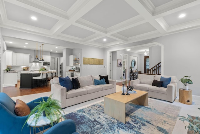 living room featuring stairs, ornamental molding, beam ceiling, and coffered ceiling