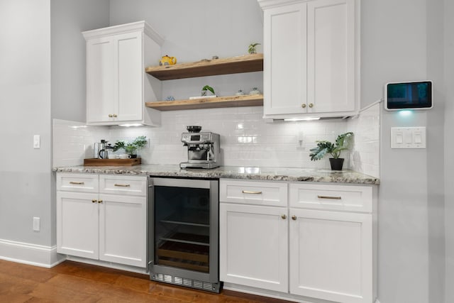 bar with baseboards, backsplash, dark wood finished floors, and beverage cooler