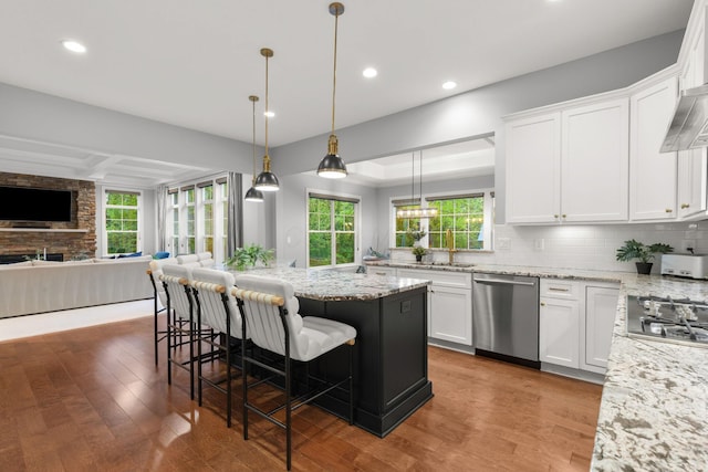 kitchen featuring open floor plan, wood finished floors, white cabinets, and stainless steel appliances