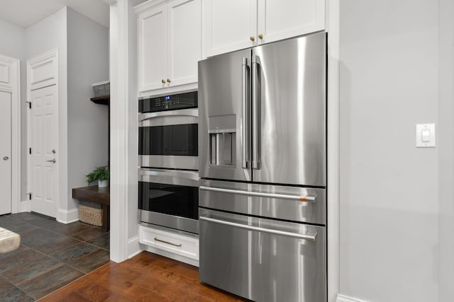 kitchen with baseboards, white cabinetry, and stainless steel appliances