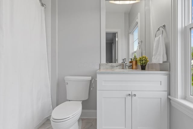 bathroom featuring toilet, baseboards, a shower with shower curtain, and vanity