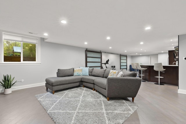 living room featuring recessed lighting, baseboards, and light wood-style flooring