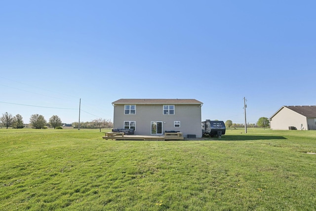 rear view of property with a wooden deck and a yard