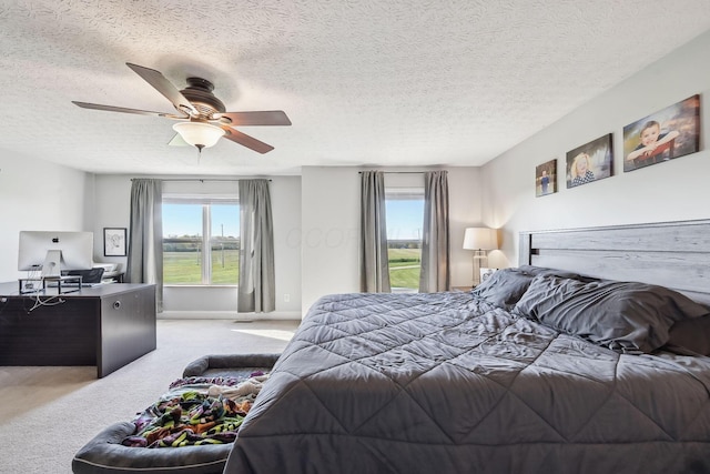 bedroom featuring a textured ceiling, multiple windows, ceiling fan, and carpet floors