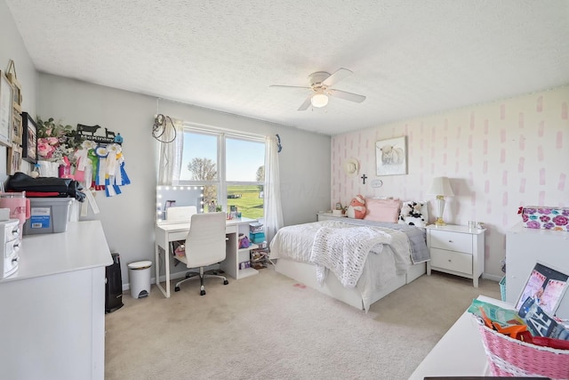 bedroom featuring ceiling fan, a textured ceiling, and light colored carpet