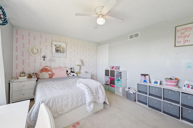 carpeted bedroom with visible vents, a ceiling fan, and wallpapered walls