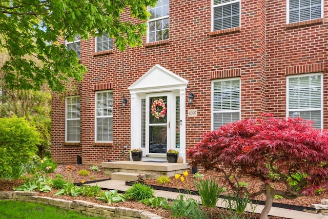 doorway to property featuring brick siding