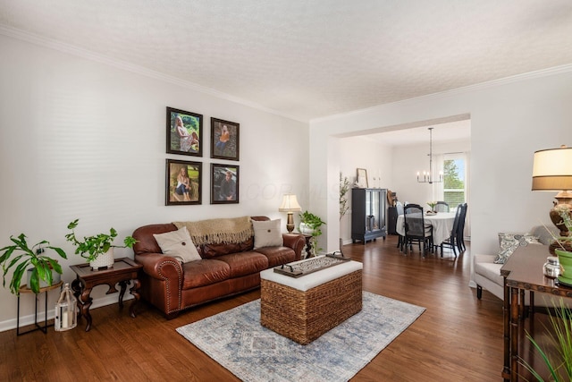 living area featuring ornamental molding, an inviting chandelier, baseboards, and dark wood-type flooring