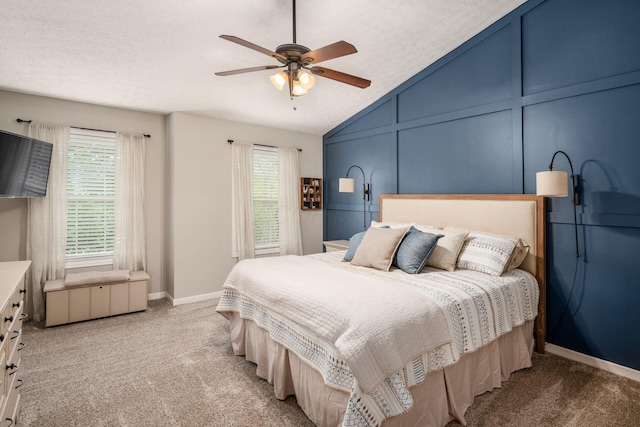 bedroom featuring a decorative wall, lofted ceiling, ceiling fan, and light colored carpet