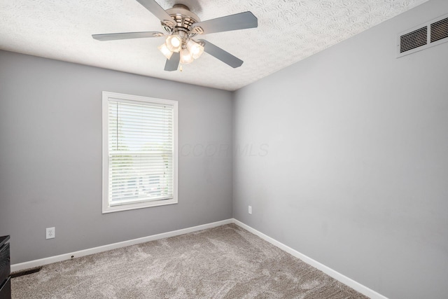 empty room featuring carpet floors, visible vents, ceiling fan, and baseboards