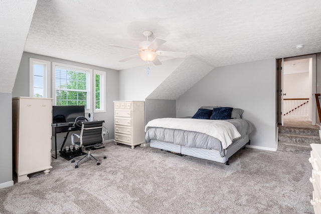 carpeted bedroom with a textured ceiling, ceiling fan, and baseboards