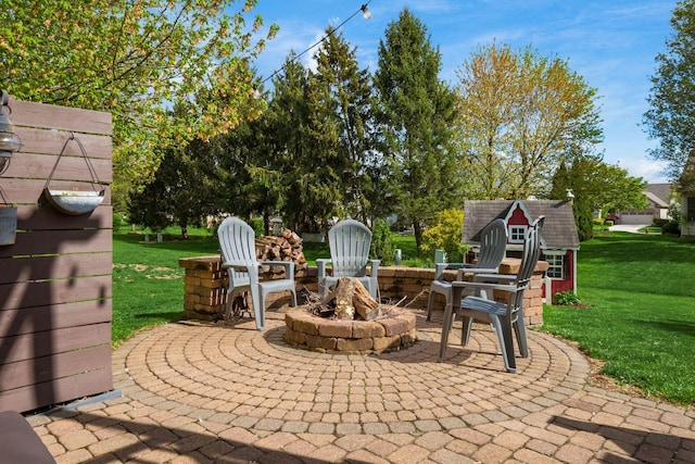 view of patio with a fire pit and an outbuilding