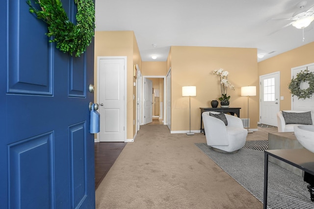 carpeted entrance foyer with a ceiling fan and baseboards