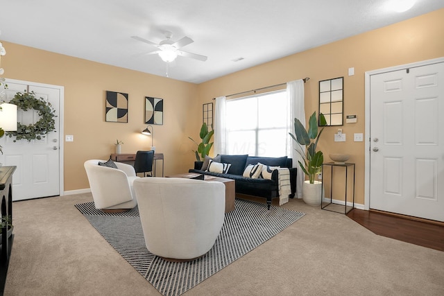 living area with a ceiling fan, baseboards, visible vents, and carpet
