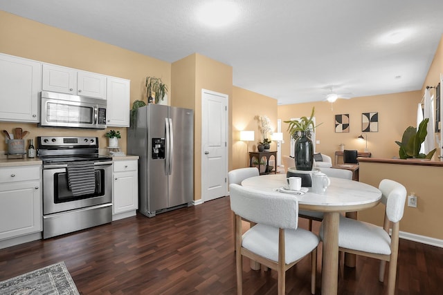 kitchen with light countertops, dark wood-style flooring, white cabinetry, and stainless steel appliances