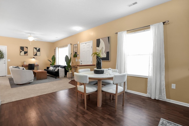 dining space featuring dark wood-style flooring, baseboards, visible vents, and a ceiling fan