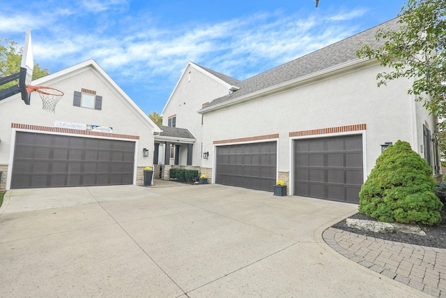 2443 Shepherd Ct, Powell, OH 43065 - view of front of house with driveway, stucco siding, an attached garage, and stone siding